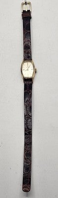 Wristwatch with a dark strap on a light gray background from our Pre-Owned & Secondhand Watches