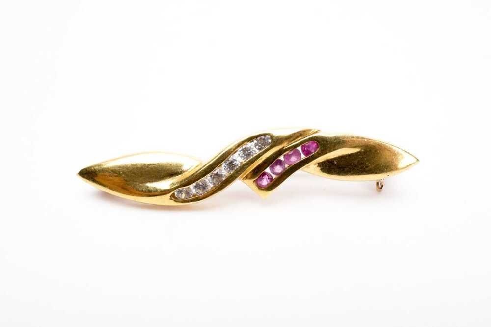 A ruby and cubic zirconia brooch in 18k yellow gold 36x7mm. 4.87 grams