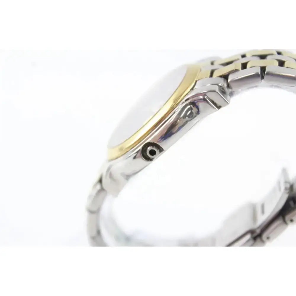 Close-up side view of a two-tone stainless steel and gold watch with a silver dial, on a white background.