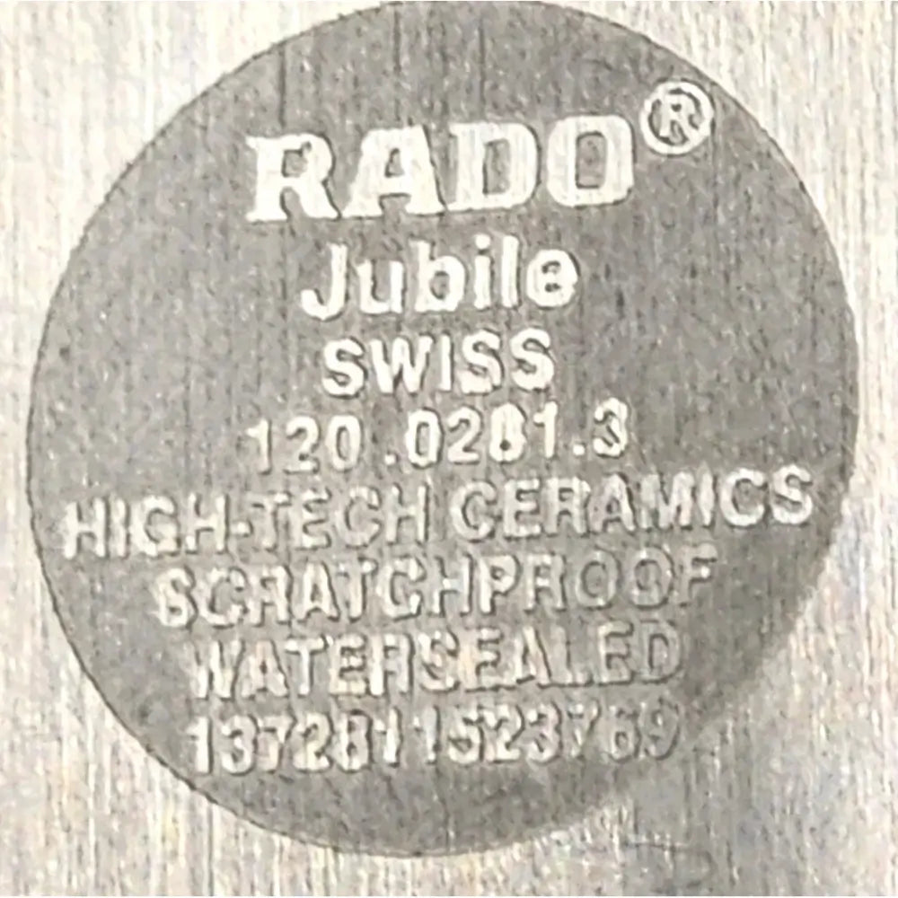 A close-up of a circular gray RADO Jubile high-tech ceramics scratchproof watersealed component on a light textured background.