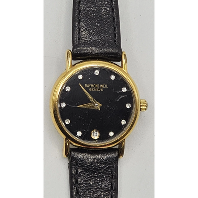 Vintage Raymond Weil watch with black face and gold accents on a gray background from our Pre-Owned & Secondhand Watches
collection 