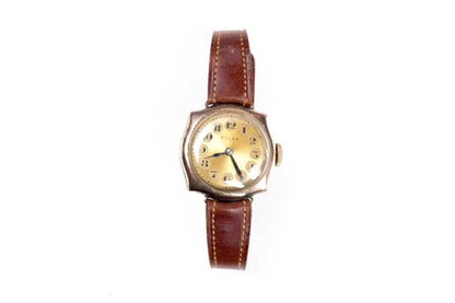 Vintage wristwatch with brown leather strap on a white background
