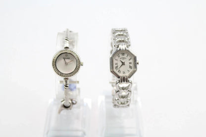 Two silver watches on white stands with a white background from our Pre-Owned & Secondhand Watches
 collection