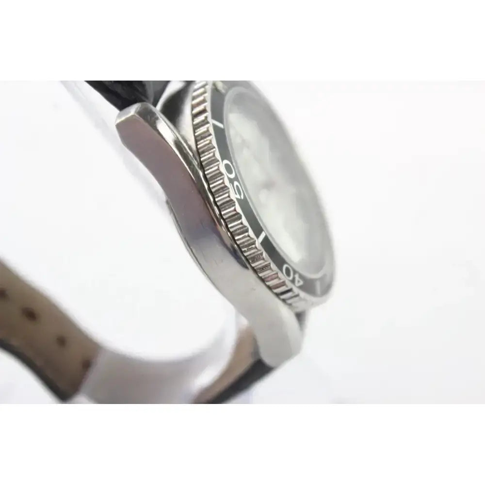 Close-up side view of a stainless steel wristwatch with a black dial and a textured bezel, attached to a light brown leather strap against a white background.