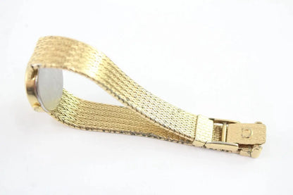 A gold-colored mesh watch band with a matching gold buckle and a silver-toned circular end cap, shown on a plain white background.