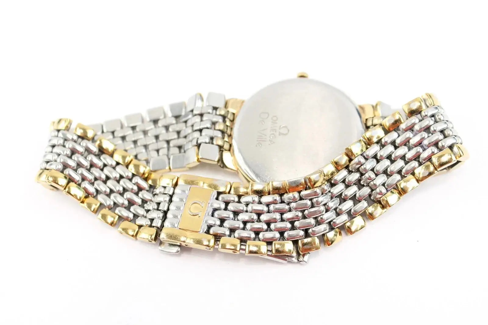 A two-tone stainless steel and gold watch band with a round silver-toned case, shown from the back on a white background.