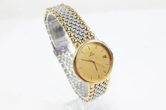 Omega women's watch with a gold dial, gold case, and a two-tone silver and gold mesh bracelet, displayed on a white background.