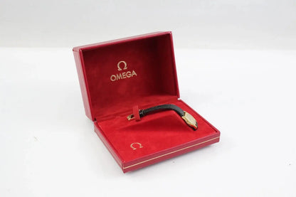 An Omega wristwatch with a black strap and gold-toned case, presented inside its open red Omega box on a white background.