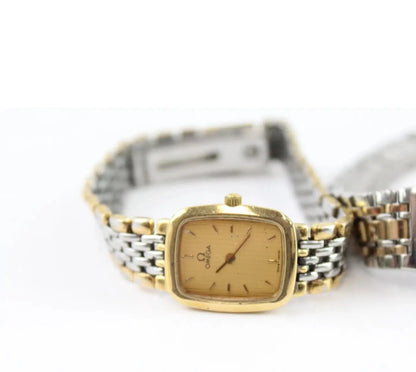 A two-tone Omega watch with a gold-toned case and dial, paired with a silver and gold-toned metal link bracelet, shown on a white background.