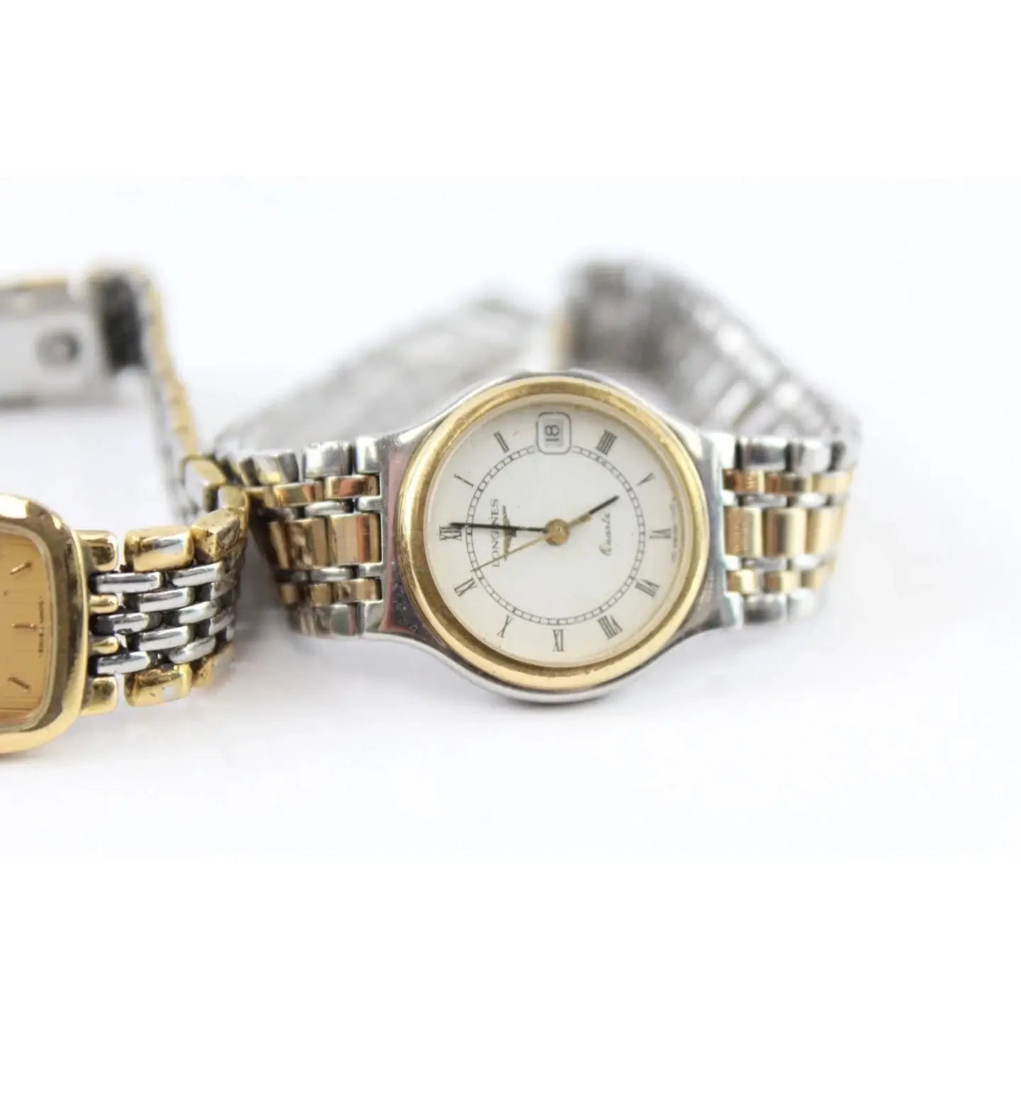A two-tone stainless steel and gold wristwatch with a white dial, shown alongside another similar watch on a plain white background.