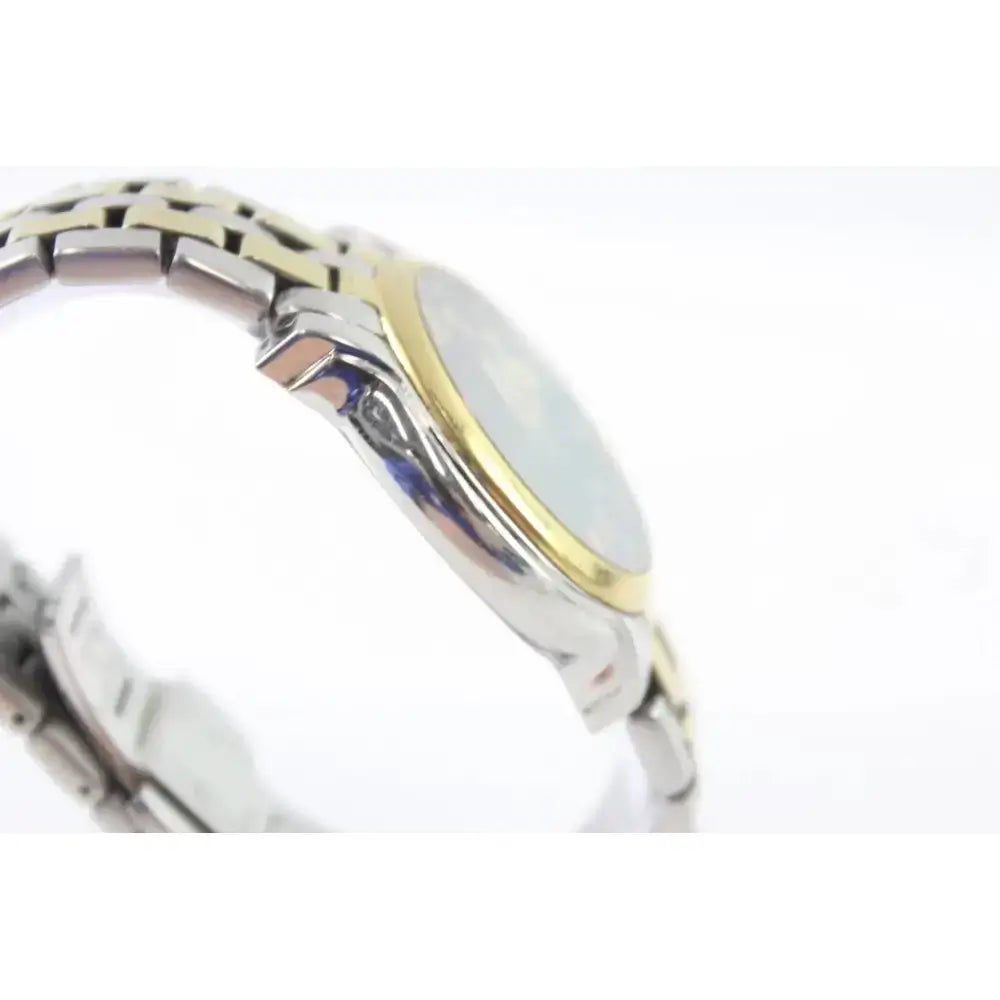 A close-up side view of a two-tone stainless steel and gold watch with a silver-toned metal link bracelet and a light-colored dial, set against a plain white background.