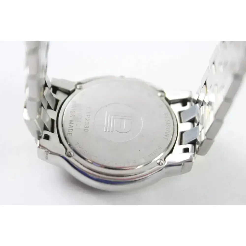 Close-up of the back of a stainless steel wristwatch with a metal link band, showing engraved details and a logo on the case against a white background.