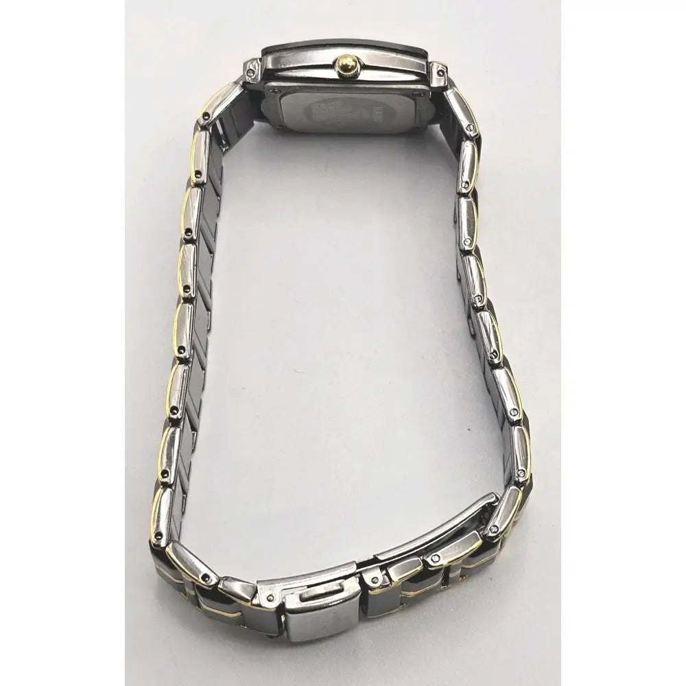 The back view of a two-tone stainless steel watch with a metal link bracelet, showing the case back and clasp on a light gray background.