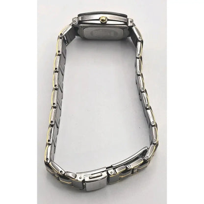 The back view of a two-tone stainless steel watch with a metal link bracelet, showing the case back and clasp on a light gray background.
