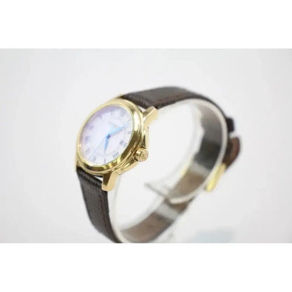 A vintage-style wristwatch with a gold-tone case, a brown leather strap, and a white dial with blue hands, displayed on a white background.