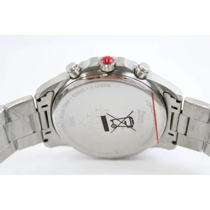 Close-up of the back of a stainless steel wristwatch with a metal link bracelet, showing the case back, pushers, and a small red accent on the crown.