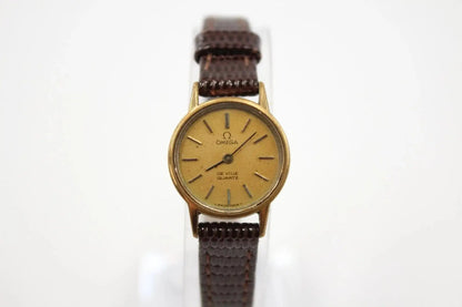 Close-up dial of Omega De Ville quartz watch showing gold tone case