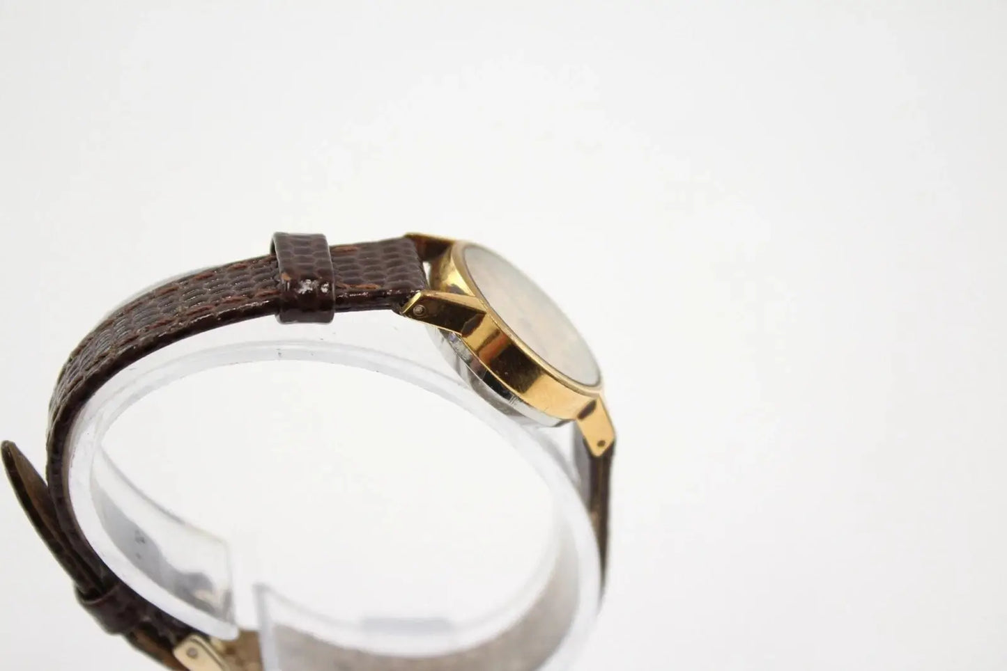 Side angle of Omega De Ville gold tone case on display stand