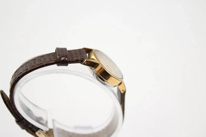 Side angle of Omega De Ville gold tone case on display stand