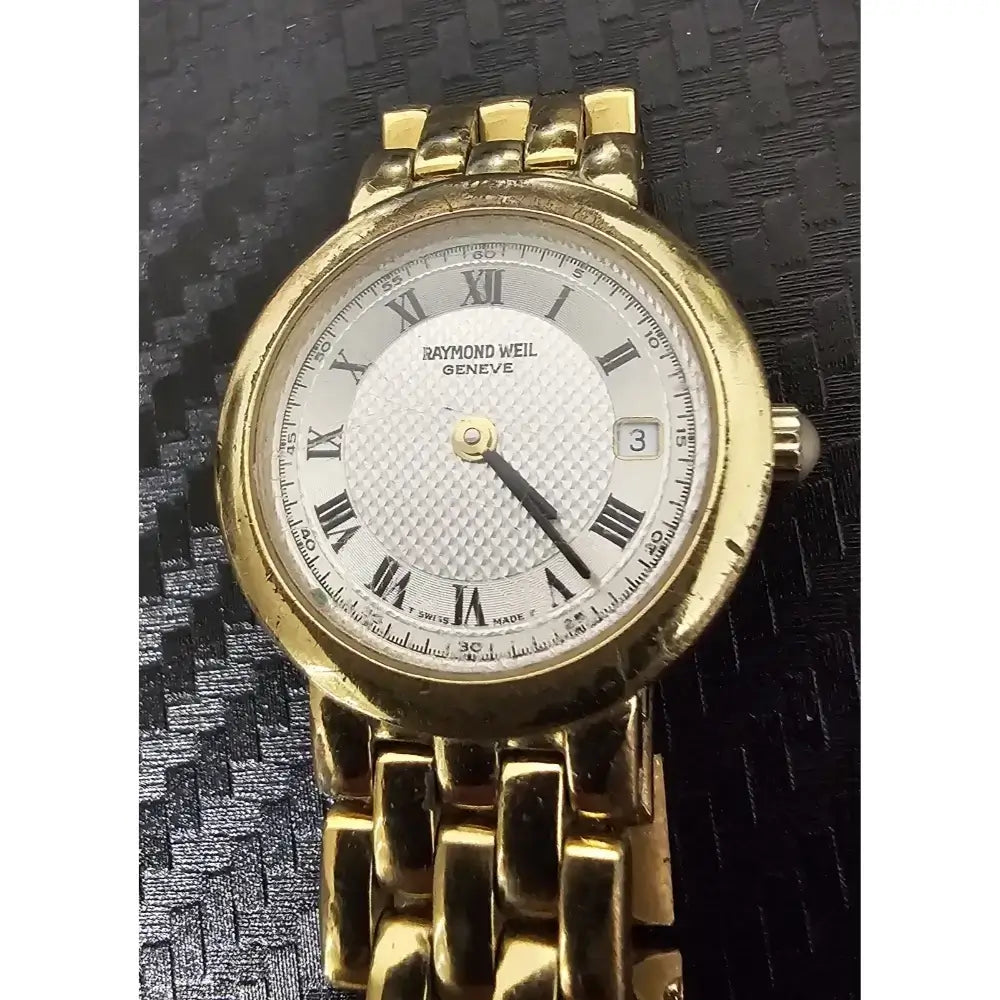 A vintage Raymond Weil Swiss watch with a gold-tone metal bracelet and case, featuring a white dial with black Roman numerals.