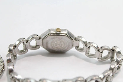 Silver-tone metal watch bracelet with a central octagonal case end and interlocking links, photographed on a plain light background.